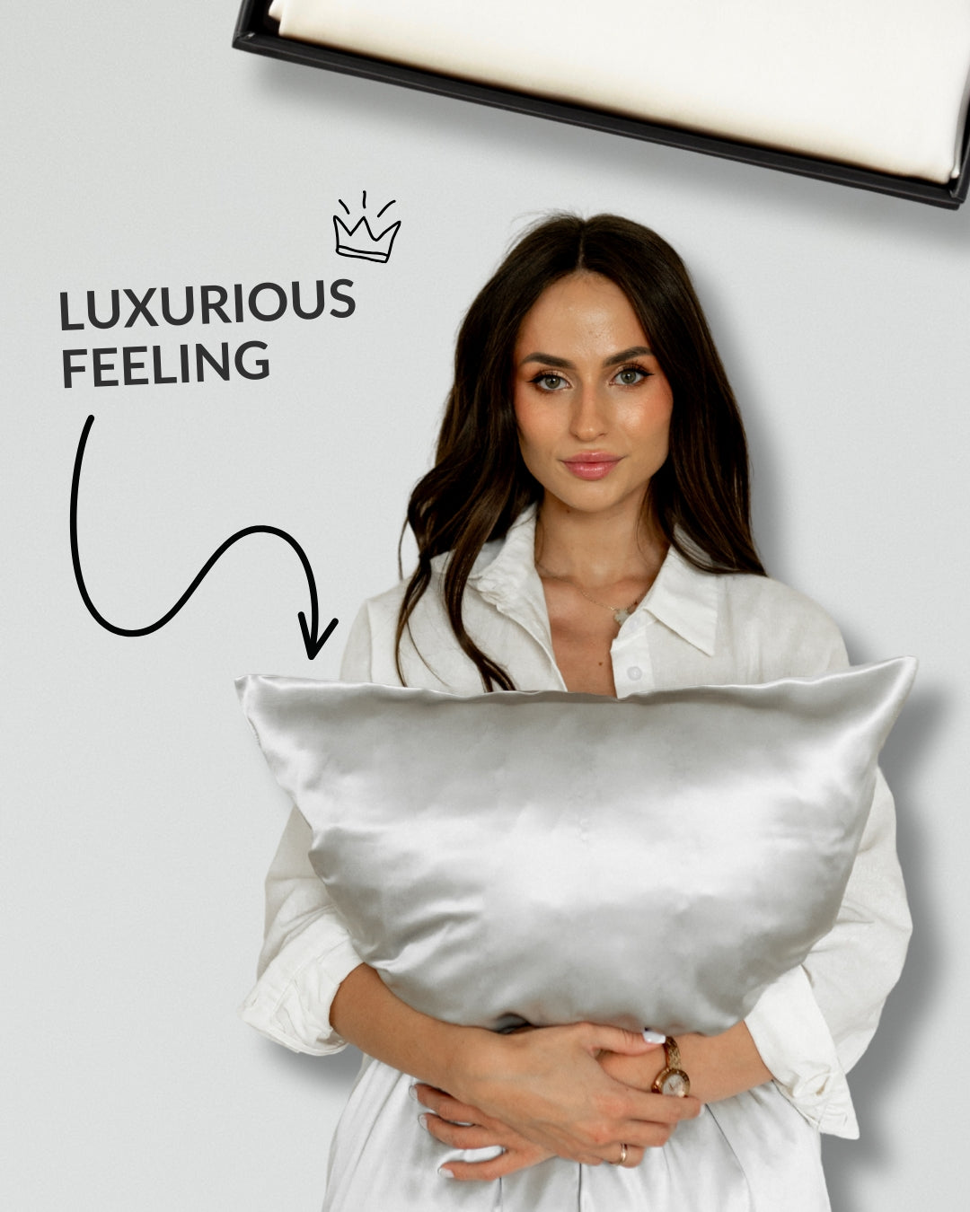 White silk pillowcase in gift box. Woman holding the pillow