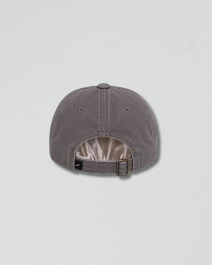 A gray six-panel baseball cap shown from the back, featuring a buttoned top and an adjustable strap with a metal buckle, set against a light gray background.